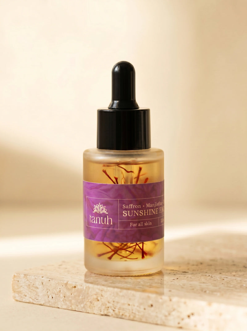 Tanuh Sunshine Face Oil, frosted dropper bottle with real saffron threads in golden oil, on travertine stone, 25 ml